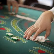 Dealer pos jitu membagikan kartu Three Card Poker di studio HD